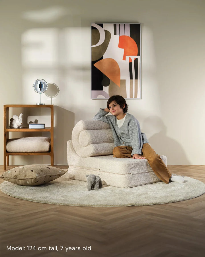 Child relaxing in Wigiwama Cream White Flipster in a cosy home interior