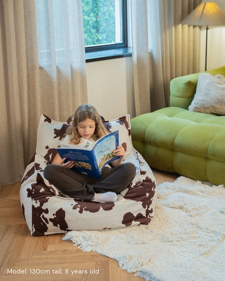 Child relaxing in Wigiwama Daisy Club Chair in a cosy home interior