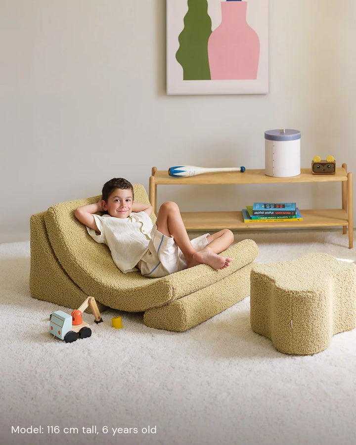 Child relaxing in Wigiwama Matcha Moon Chair in a cosy home interior