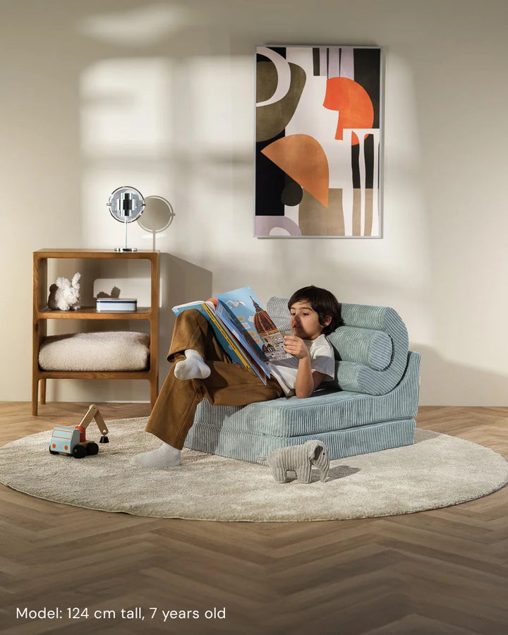 Child relaxing in Wigiwama Peppermint Green Flipster in a cosy home interior