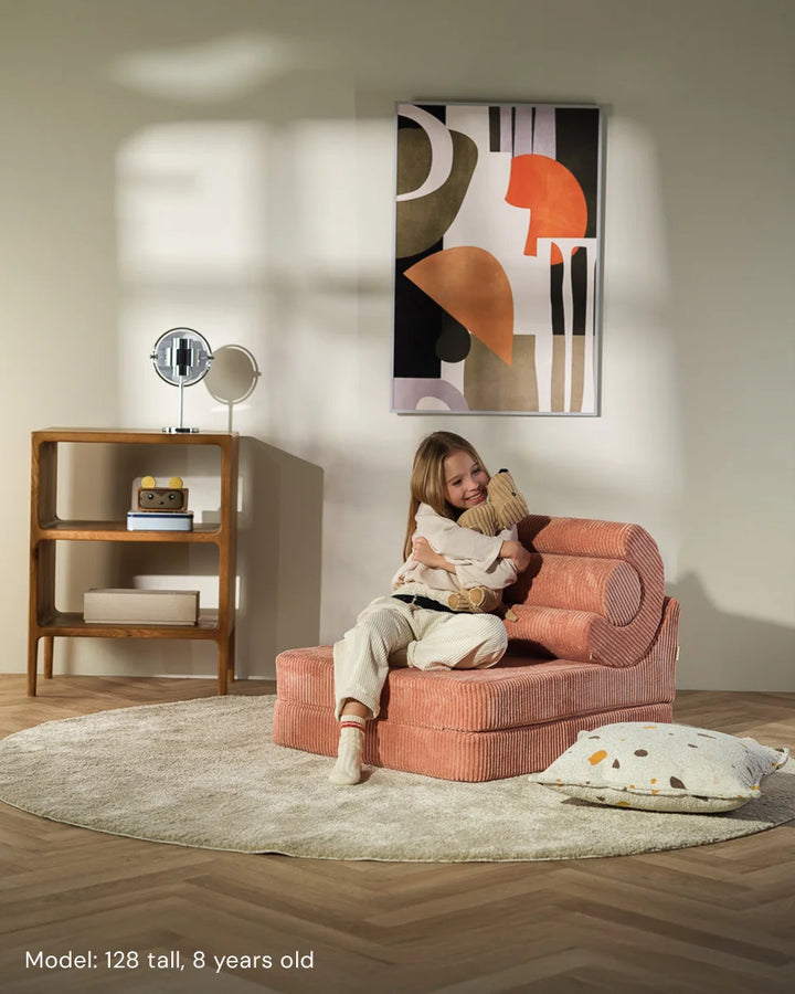 Child relaxing in Wigiwama Pink Mousse Flipster in a cosy home interior