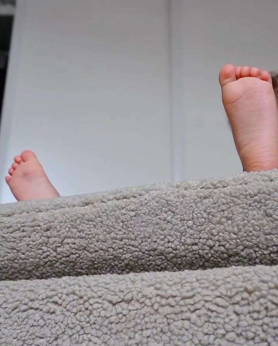 Close-up of a child’s feet resting on a soft Wigiwama teddy Moon Chair — a moment of calm and comfort