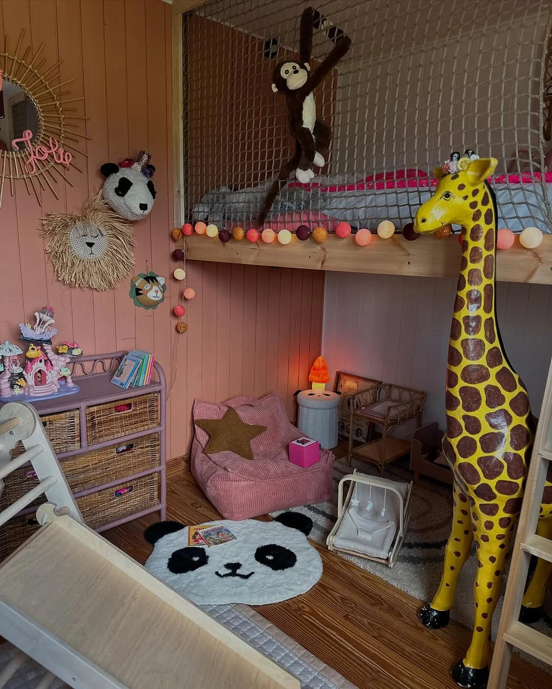 Playful kids room with bunk bed, hanging monkey toy, giraffe decor, and cosy Wigiwama seating in a warm, earthy interior