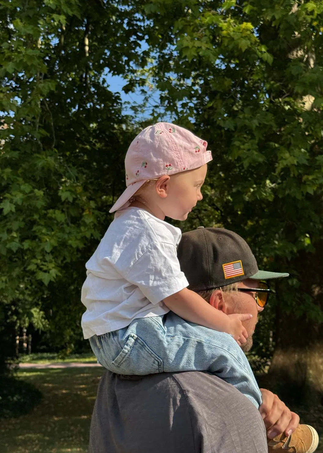 A father carries his young child on his shoulders during a family day at the Flora park in Cologne.