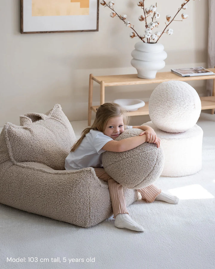 Child relaxing in Wigiwama Biscuit Beanbag Chair in a cosy home interior