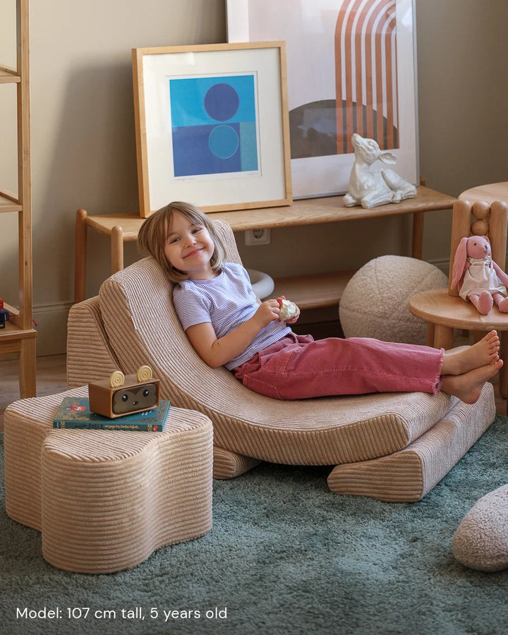 Child relaxing in Wigiwama Brown Sugar Moon Chair in a cosy home interior