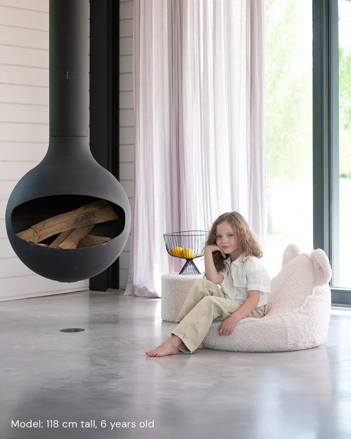 Child relaxing in Wigiwama Cream White Bear Beanbag in a cosy home interior