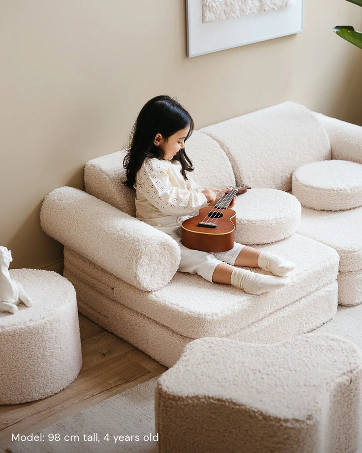 Child relaxing in Wigiwama Cream White Settee in a cosy home interior