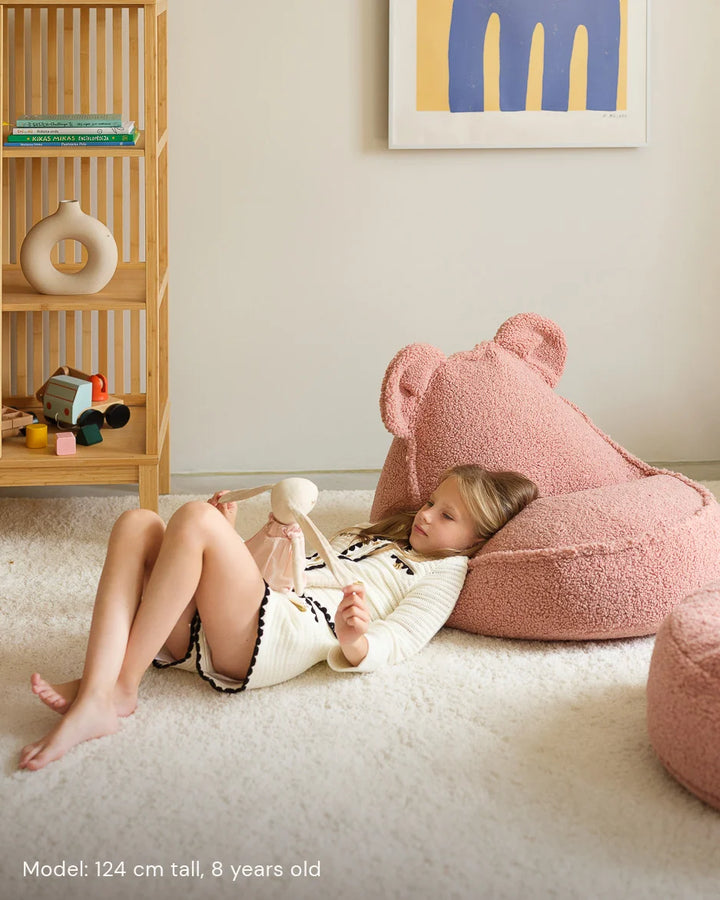 Child relaxing in Wigiwama Guava Bear Beanbag in a cosy home interior
