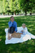 A peaceful picnic scene in a Copenhagen park — a mother and son sit barefoot on a blanket, enjoying the sunshine and snacks.