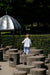 A young boy walking barefoot on wooden stumps at a natural playground in King’s Garden, Copenhagen.
