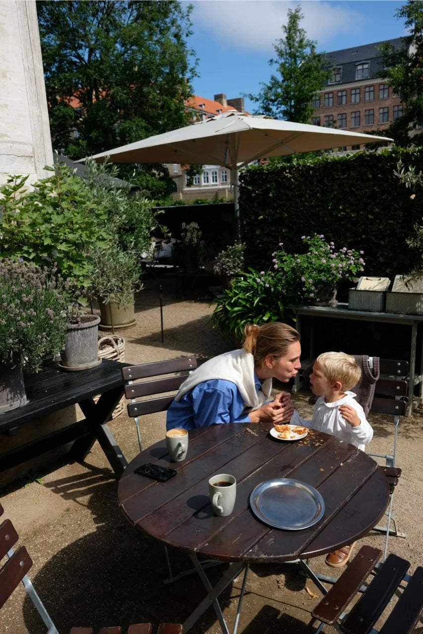 Lea Sørensen sharing a quiet moment with her son over coffee and pastries at Hercules Pavilion in Copenhagen.