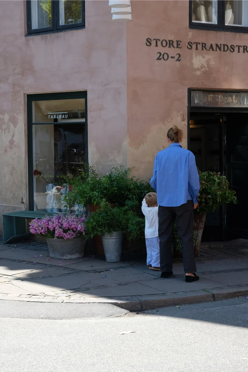 Lea Sørensen and her child standing outside Tableau flower shop on Store Strandstræde in Copenhagen.