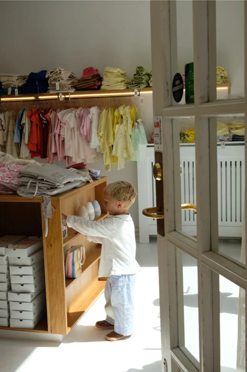 A young boy exploring inside COlabel, a thoughtfully curated children’s store in Copenhagen.