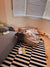 Toddler exploring toys around a Wigiwama beanbag in a real-life play space with books, mess, and warmth