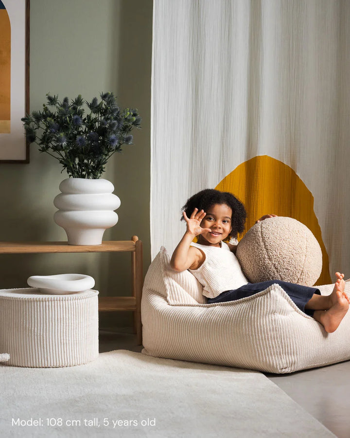 Child relaxing in Wigiwama Marshmallow Beanbag Chair in a cosy home interior