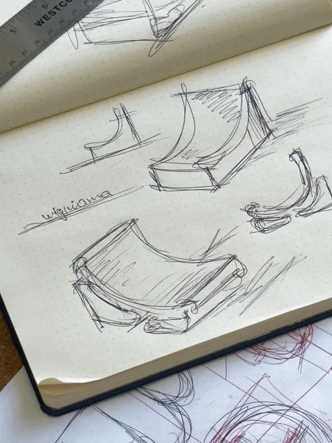 Design sketches of the Wigiwama Moon Chair in a dotted notebook, showing early concept development and form exploration.