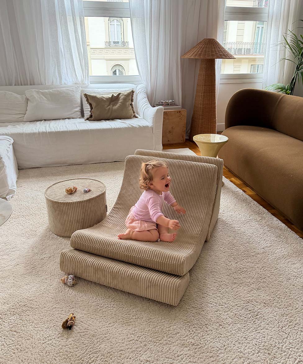 Girl sitting on a Wigiwama Brown Sugar Moon Chair in a living room with neutral decor