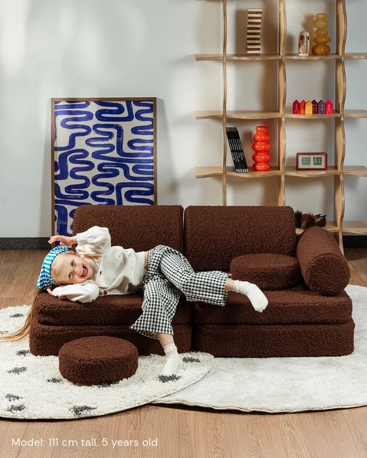Child relaxing in Wigiwama Warm Hazel Settee in a cosy home interior